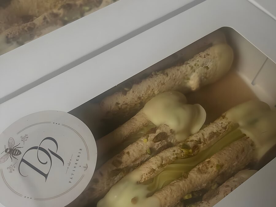 Twee dozen minibokkepoten met pistache, klaar om opgehaald te worden, met het DP-zegel erop