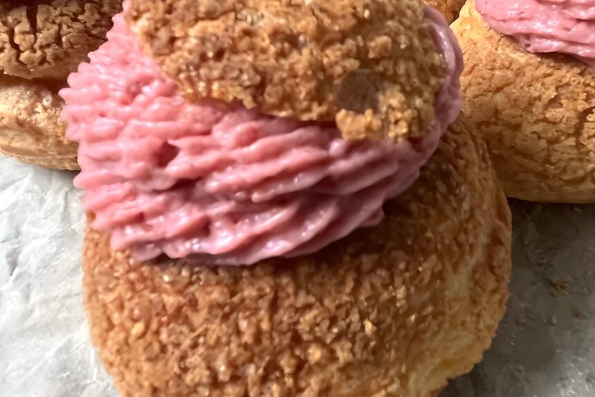 Soesjes met roze crème op een bakplaat